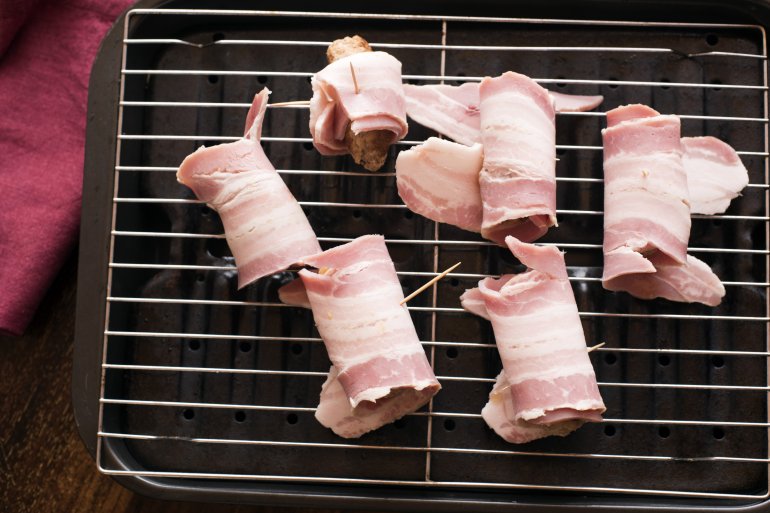 Making a batch of pigs in blankets or bacon rolls Free Stock Image